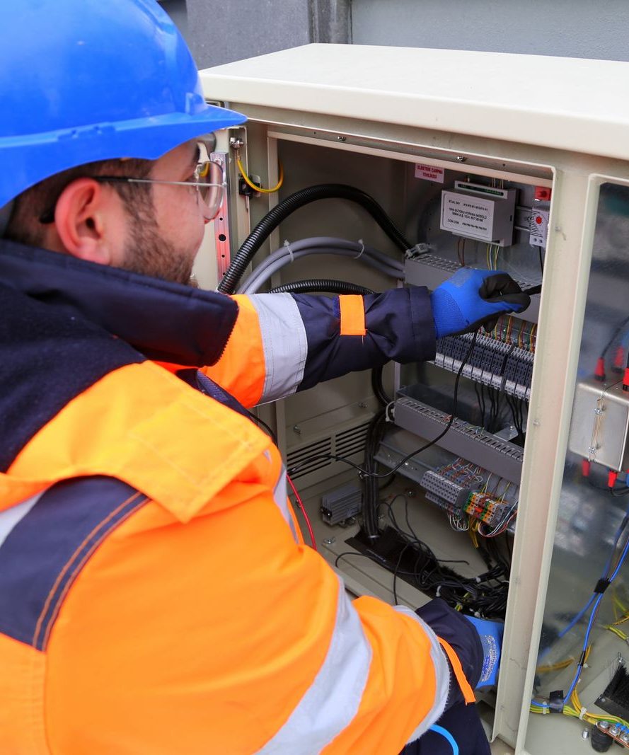 Technician servicing an outdoor electrical cabinet